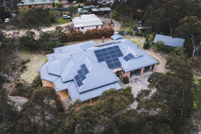 An aerial view of a house with solar panels on the roof.