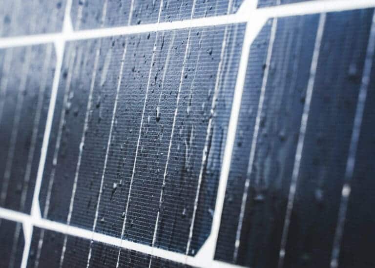 A close up of a solar panel with water droplets on it.