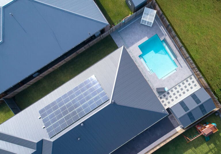 An aerial view of a house with a pool and solar panels.
