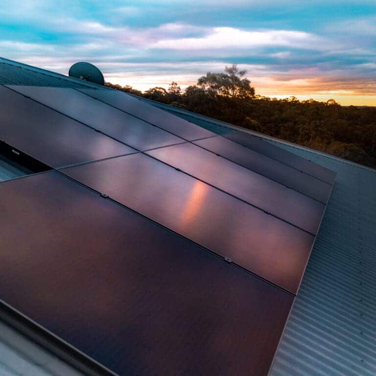Solar panels on a roof at sunset.