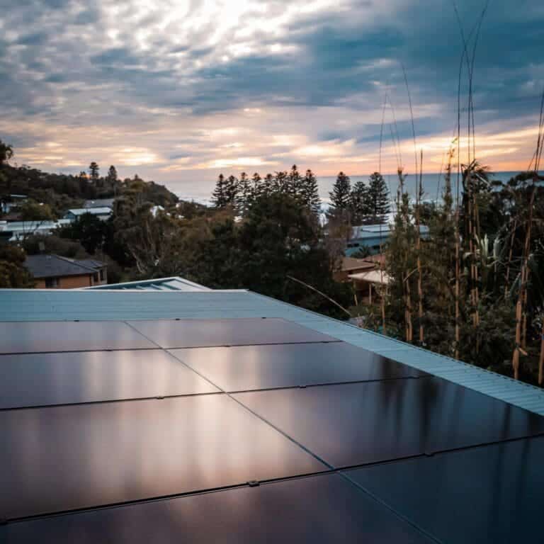 A solar panel on a roof overlooking the ocean.