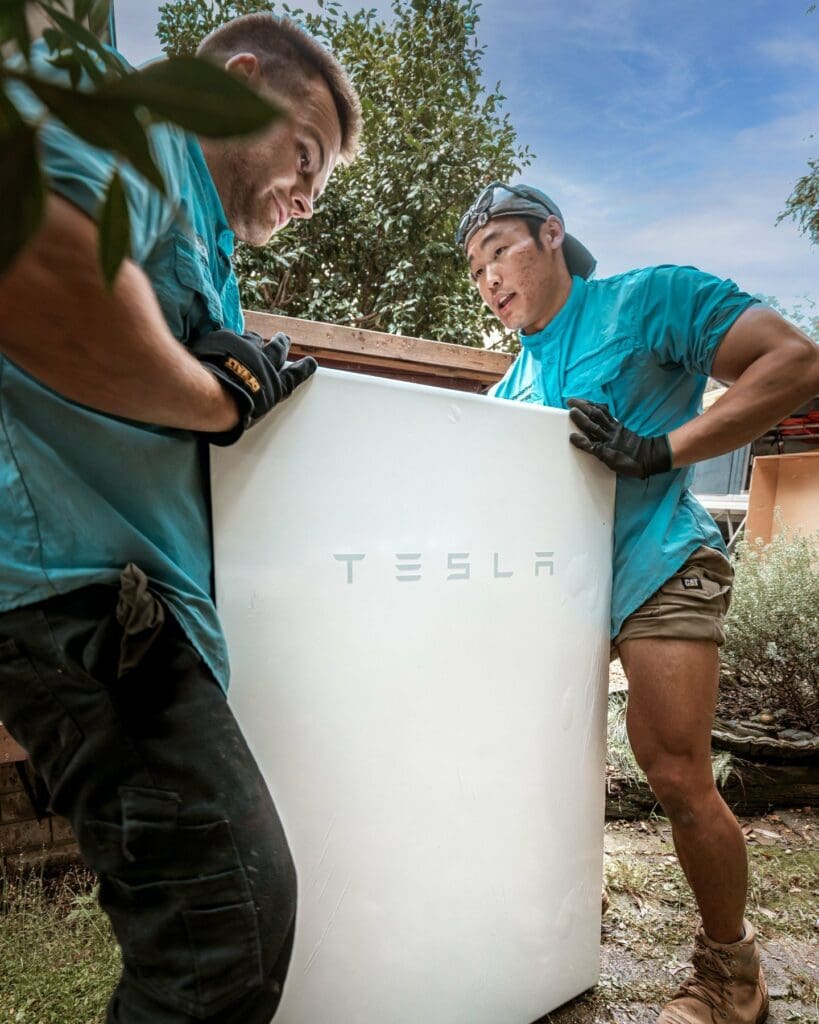 Two men working on a tesla battery.