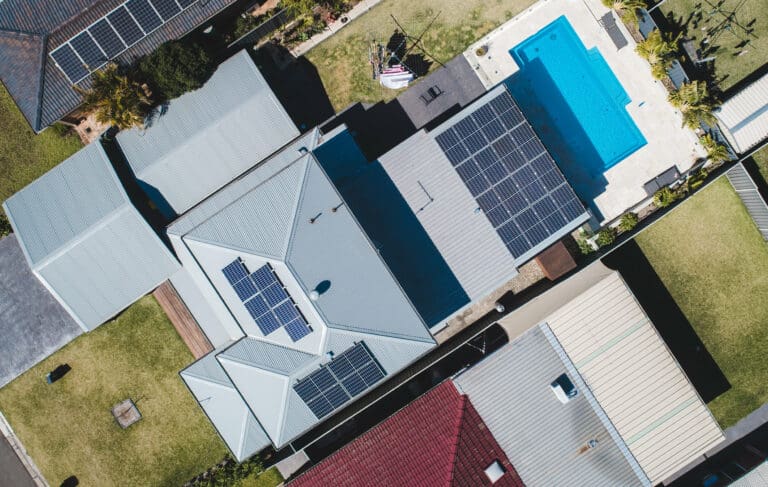An aerial view of a house with solar panels on the roof.
