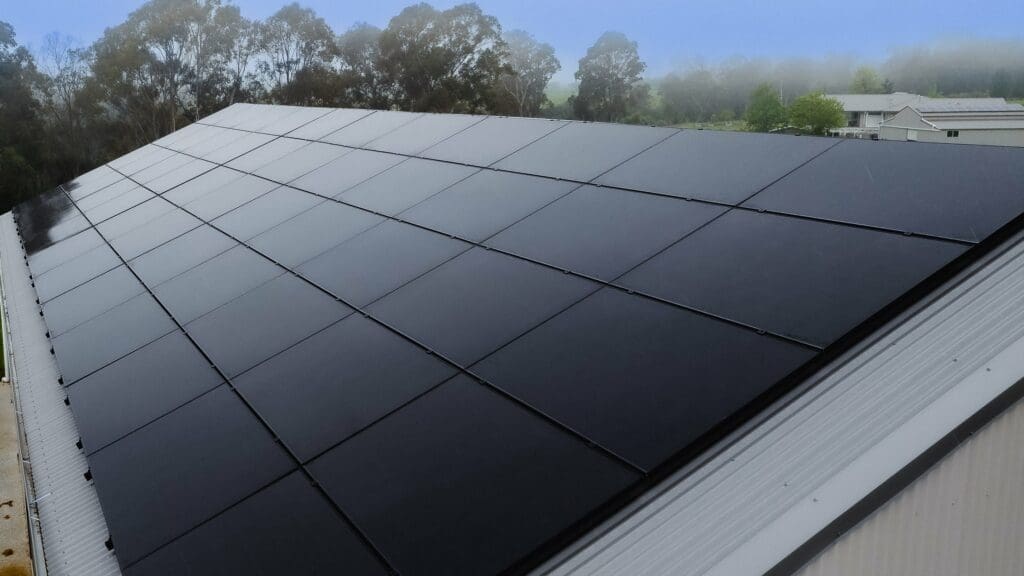 A black solar panel on the roof of a building.