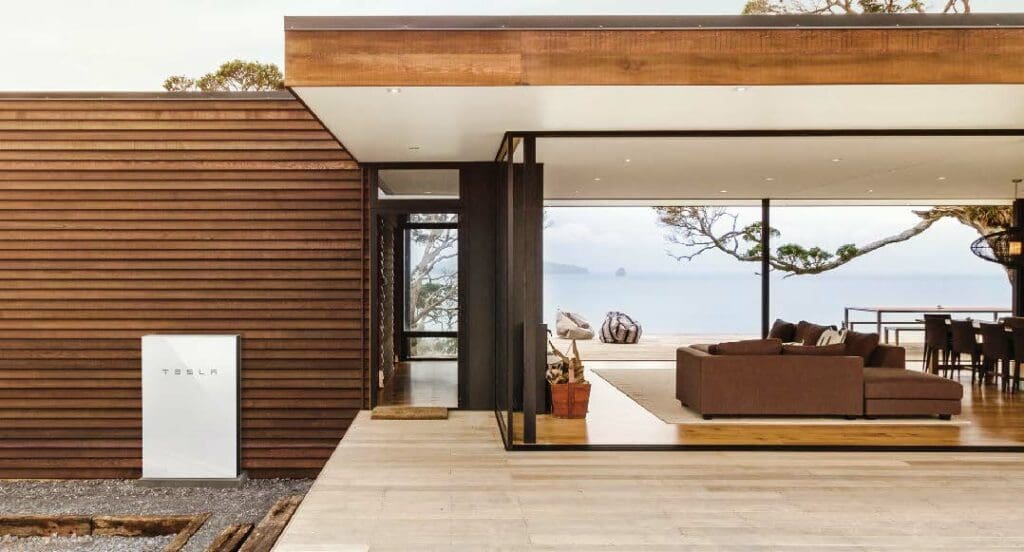 A modern house with a view of the ocean and a tesla powerwall. 