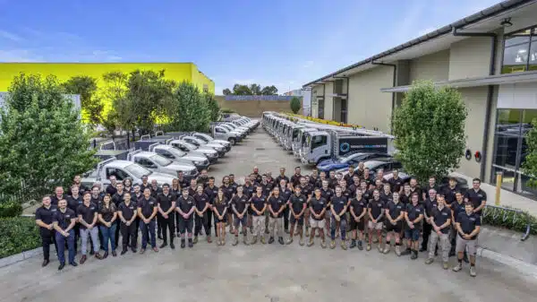 A group of people posing in front of a building at Penrith Solar Centre.