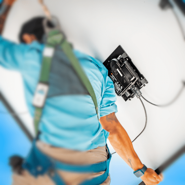 Man carrying solar panel with microinverter.